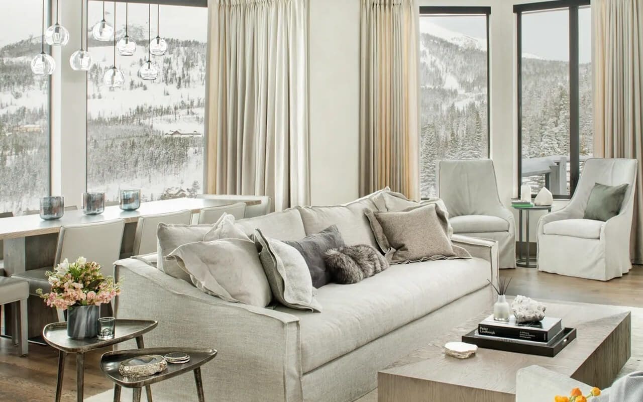 A living room with white furniture and windows.